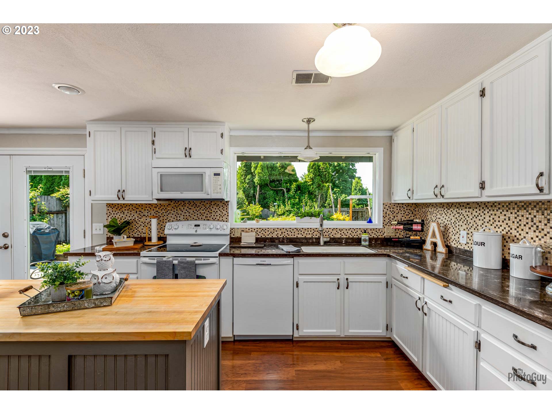 5621 C Street Springfield, OR 97478 - Photo 10 of 29 a kitchen with kitchen island granite countertop a stove a sink and white cabinets
