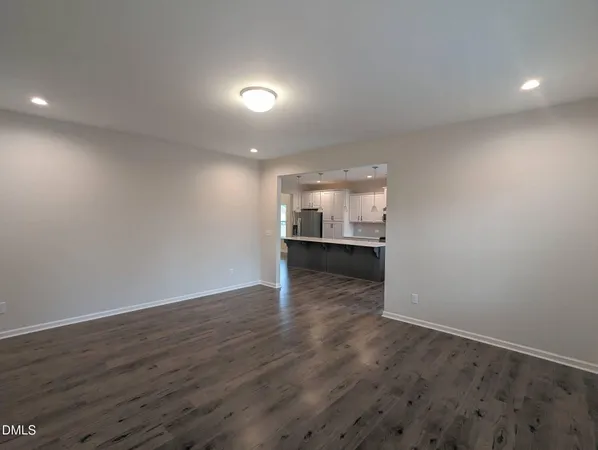a view of a room with wooden floor and kitchen