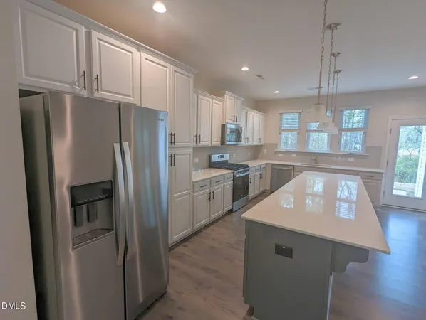 a kitchen with stainless steel appliances a refrigerator sink and cabinets