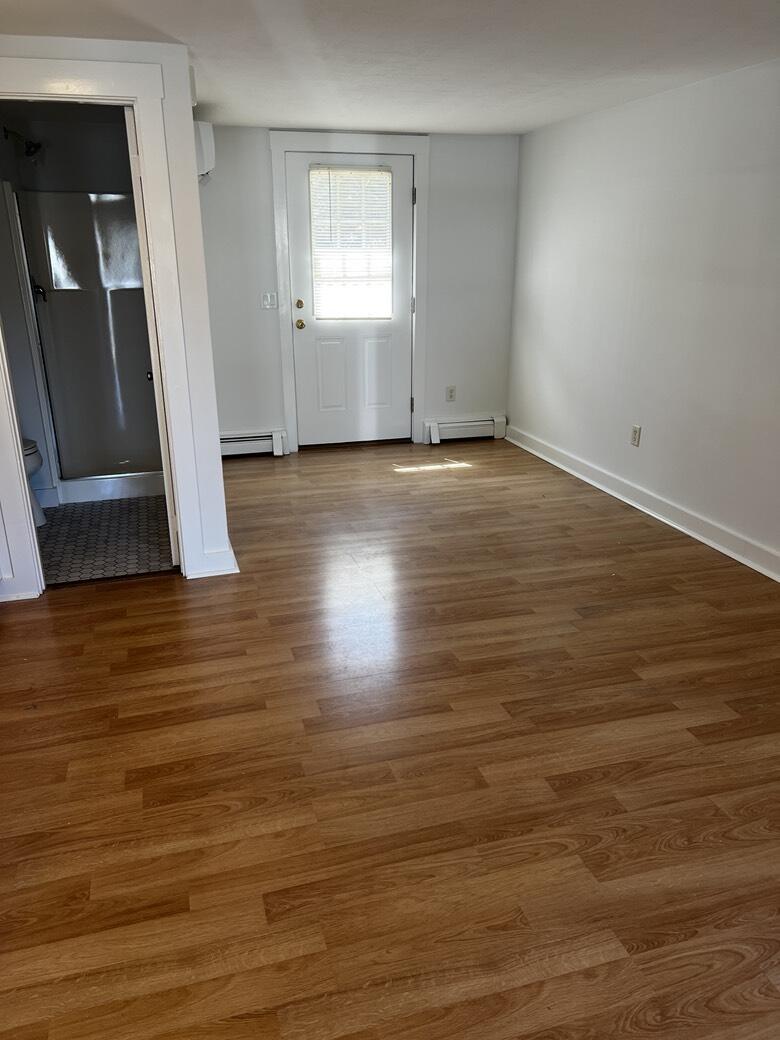 237 Route 28, Unit 3 Harwich, MA 02671 - Photo 4 of 7 an empty room with wooden floor and windows