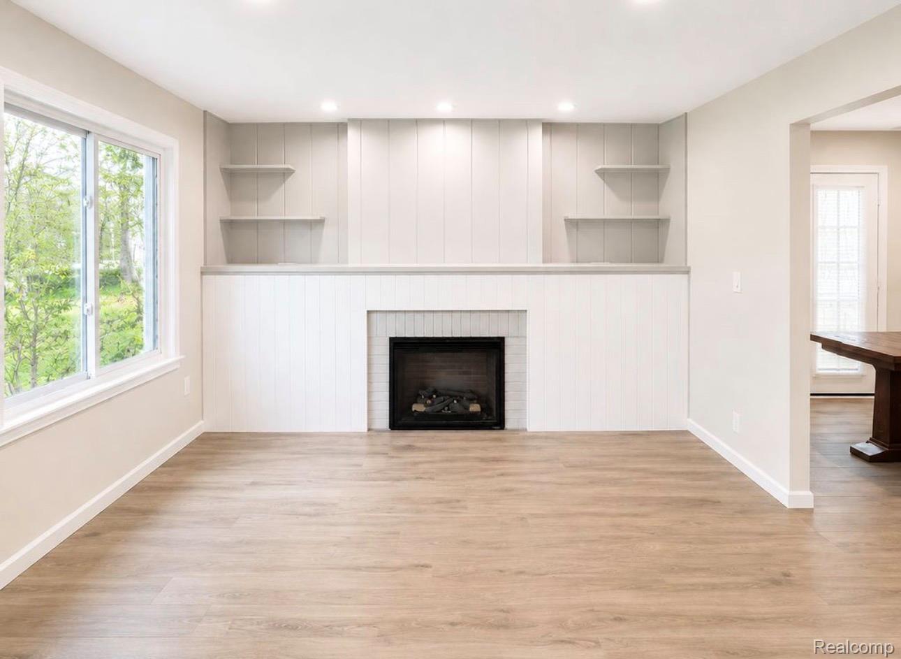 3428 Hazelton Avenue Rochester, MI 48307 - Photo 2 of 5 Living area featuring a fireplace with a light-toned tile surround, built-in shelving, wood-finish flooring, and recessed lighting