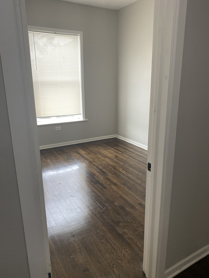 7425 South Princeton Avenue, Unit 1 Chicago, IL 60621 - Photo 17 of 24 an empty room with wooden floor and windows