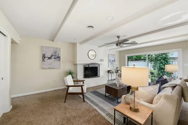 a living room with furniture a fireplace and a large window