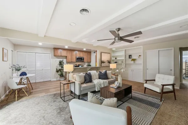a living room with furniture kitchen view and a window