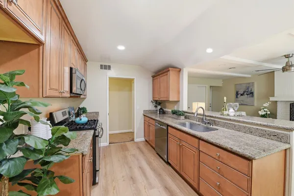 a kitchen with stainless steel appliances granite countertop sink stove top oven and cabinets