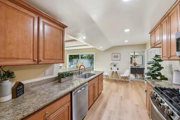 a kitchen with granite countertop a sink stove and cabinets