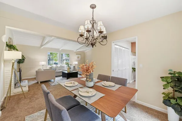 a view of a dining room with furniture and chandelier
