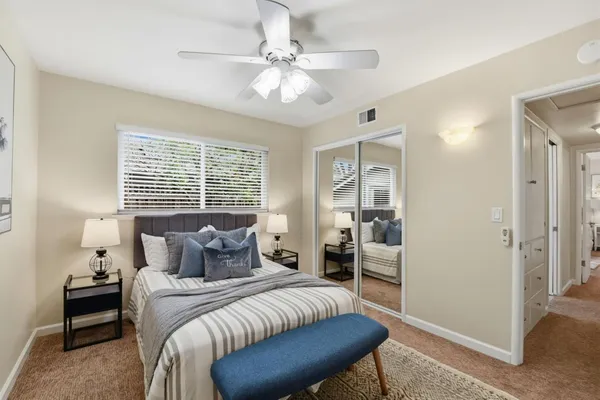 a bedroom with a large bed couch and a window