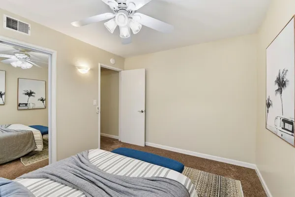 a bedroom with a large bed and a chandelier