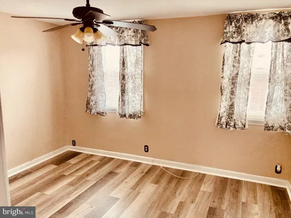 a view of a room with a window and a ceiling fan