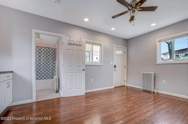 a view of a kitchen with wooden floor and a ceiling fan