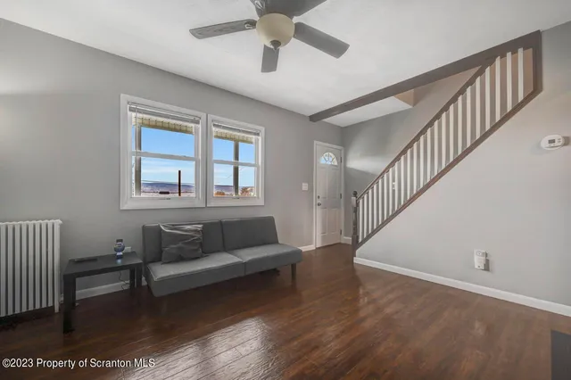 a kitchen with stainless steel appliances granite countertop a refrigerator a stove a sink and white cabinets with wooden floor