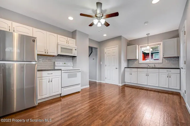 a kitchen with granite countertop a sink and wooden floor