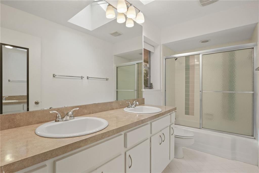 705 Edgewater Trail Sandy Springs, GA 30328 - Photo 24 of 36 a bathroom with a sink double vanity granite tub and a mirror