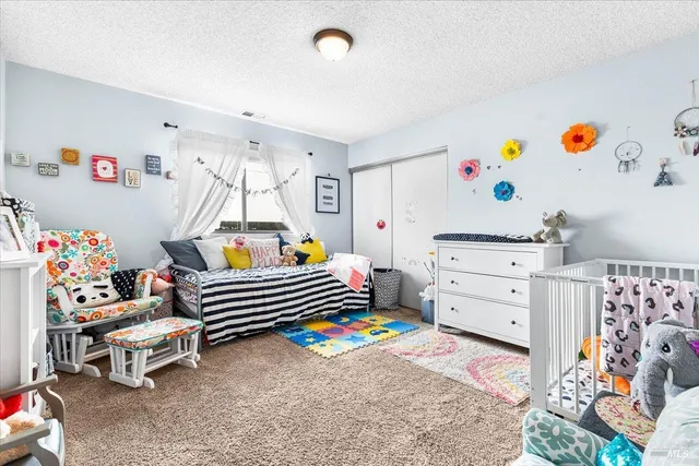 a living room with furniture and baby crib