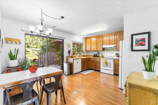 a kitchen with a table chairs stove and white cabinets