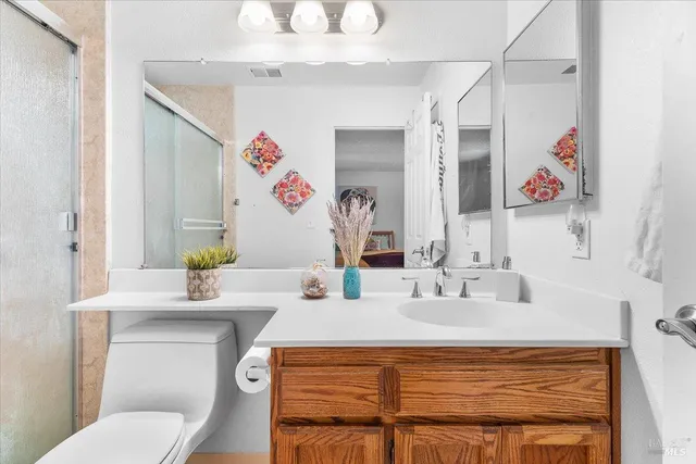 a bathroom with a sink vanity mirror and toilet