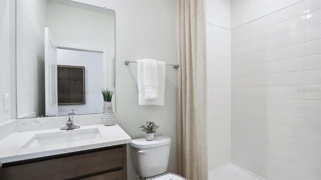 2361 Rikkola Lane Wesley Chapel, FL 33543 - Photo 16 of 28 a bathroom with a toilet a sink and a mirror