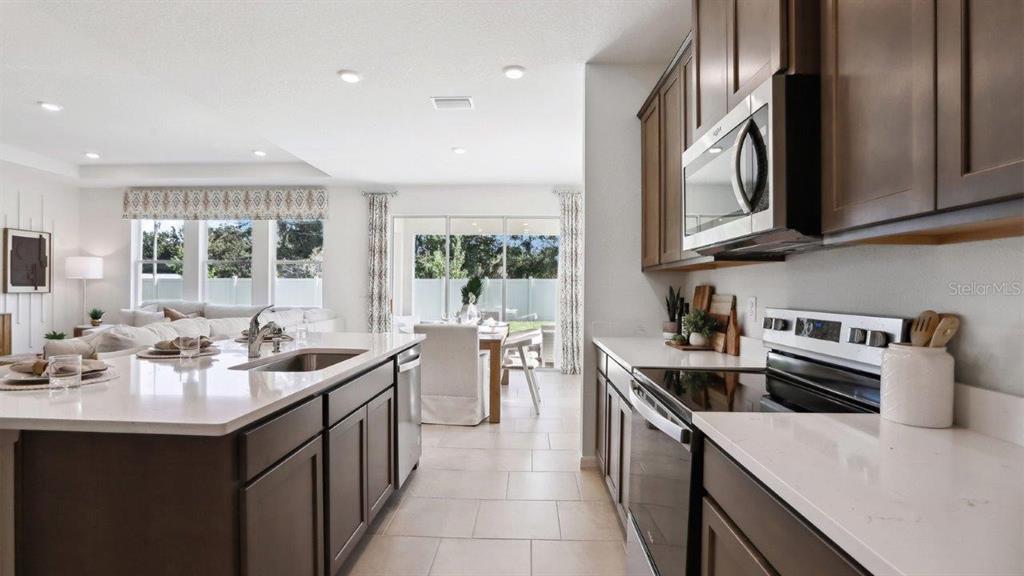 2361 Rikkola Lane Wesley Chapel, FL 33543 - Photo 8 of 28 a kitchen with stainless steel appliances a sink stove top oven and cabinets