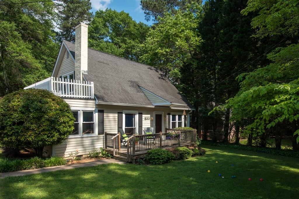 833 Sycamore Drive Decatur, GA 30030 - Photo 1 of 1 New England Cape with front porch deck and Bocci Ball front yard sunken with garden wall buffering sidewalk lined street