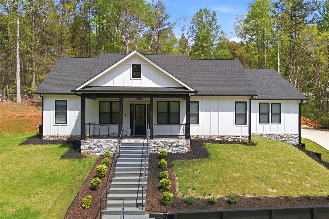 This captivating home features board and batten siding, a charming porch, and a well-maintained lawn.