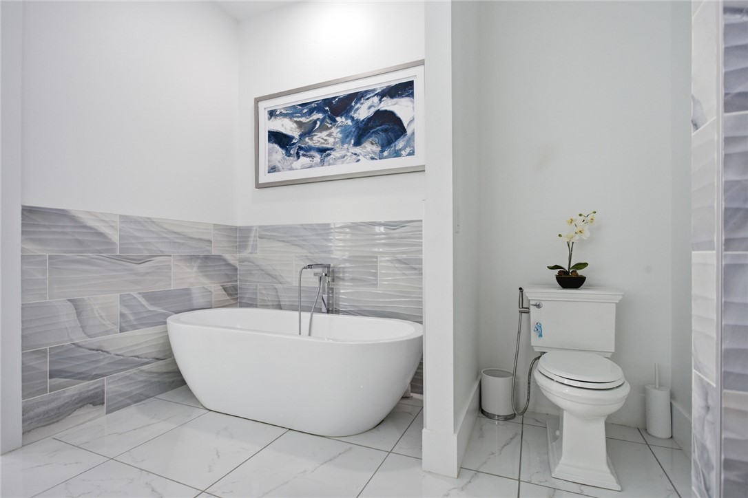 2585 Dr Johns Road Westminster, SC 29693 - Photo 21 of 40 This serene bathroom offers a spacious soaking tub and sleek modern tiling, creating a tranquil retreat.