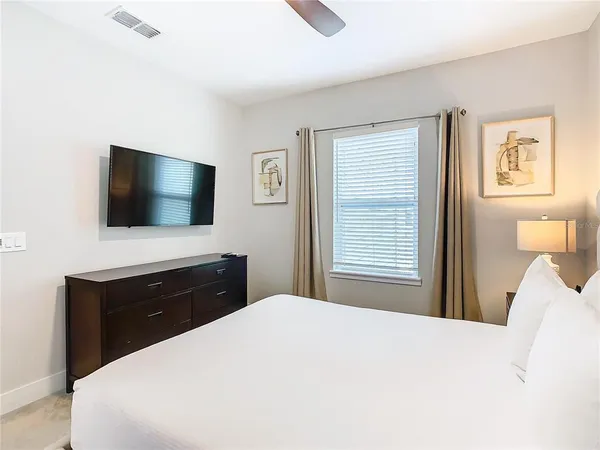 a bedroom with a bed and a flat screen tv