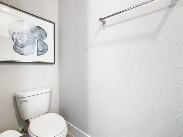 a white toilet sitting next to a white wall