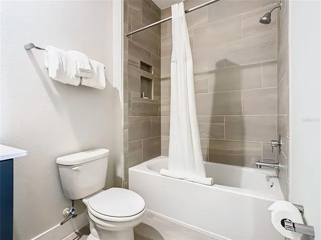 a white toilet sitting next to a bath tub and shower