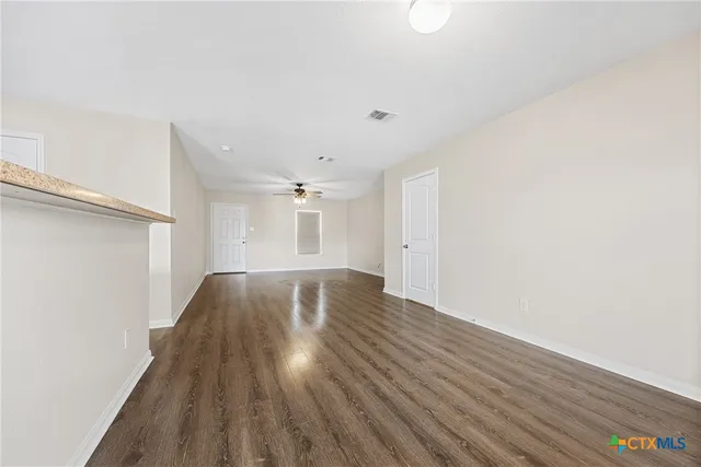 a view of empty room with wooden floor