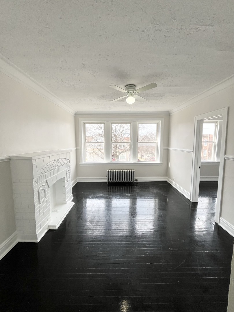 4134 West 24th Place, Unit E2 Chicago, IL 60623 - Photo 2 of 9 a view of an empty room with wooden floor and a window