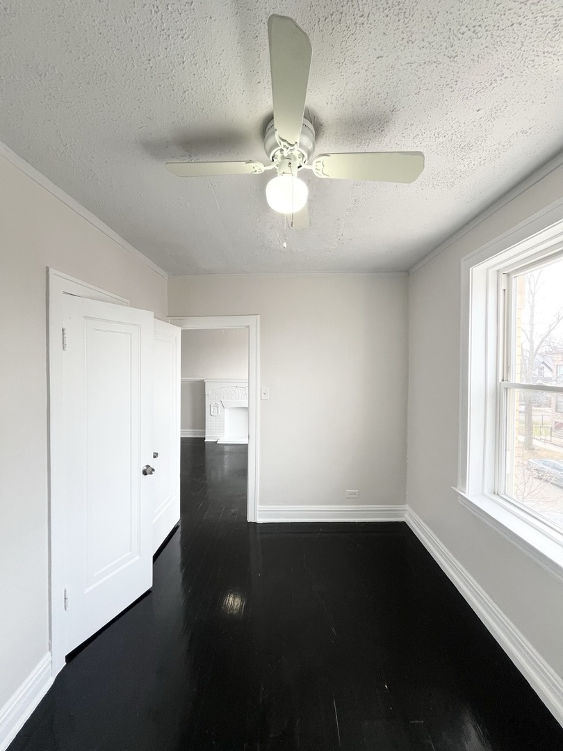 4134 West 24th Place, Unit E2 Chicago, IL 60623 - Photo 3 of 9 wooden floor in an empty room with a window
