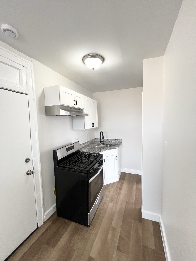 4134 West 24th Place, Unit E2 Chicago, IL 60623 - Photo 6 of 9 a kitchen with stainless steel appliances granite countertop a stove and a refrigerator