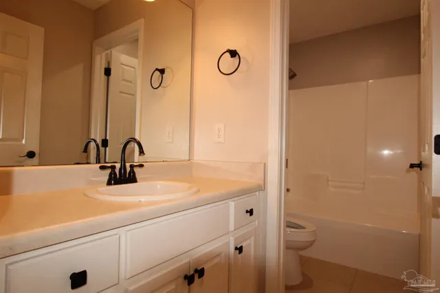 a bathroom with a sink a toilet a mirror and shower