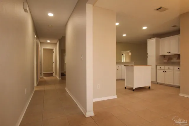 a view of a kitchen with refrigerator and white cabinets