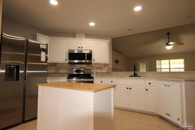 a kitchen with a sink a microwave a stove and refrigerator