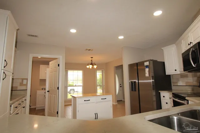 a kitchen with stainless steel appliances granite countertop a refrigerator and a sink
