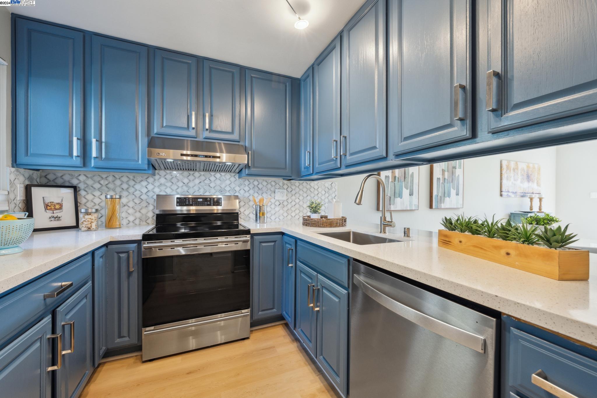 a kitchen with granite countertop stainless steel appliances stove and cabinets