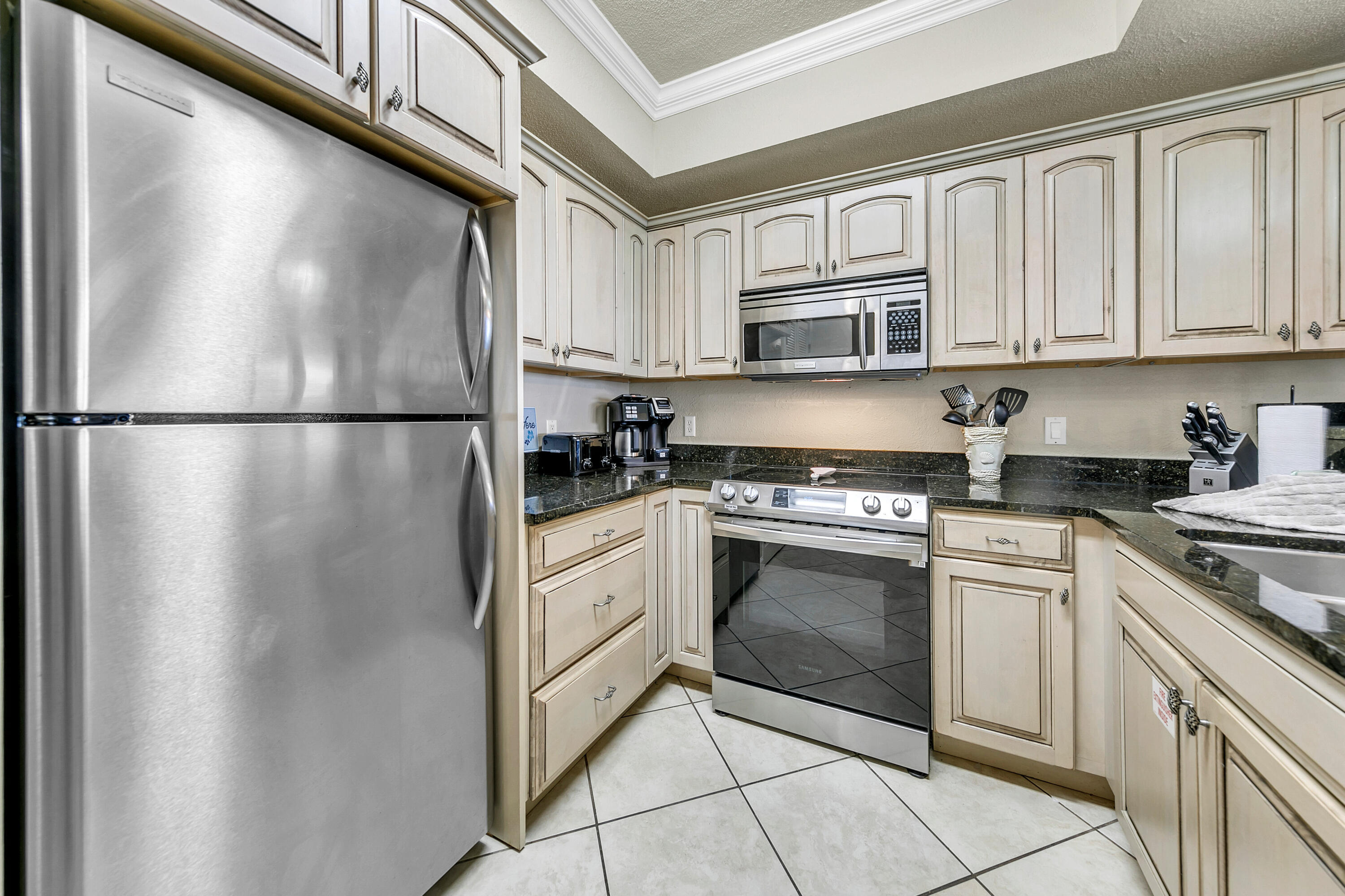 515 Tops'l Beach Boulevard, Unit 913 Miramar Beach, FL 32550 - Photo 8 of 34 a kitchen with stainless steel appliances granite countertop a refrigerator sink and cabinets