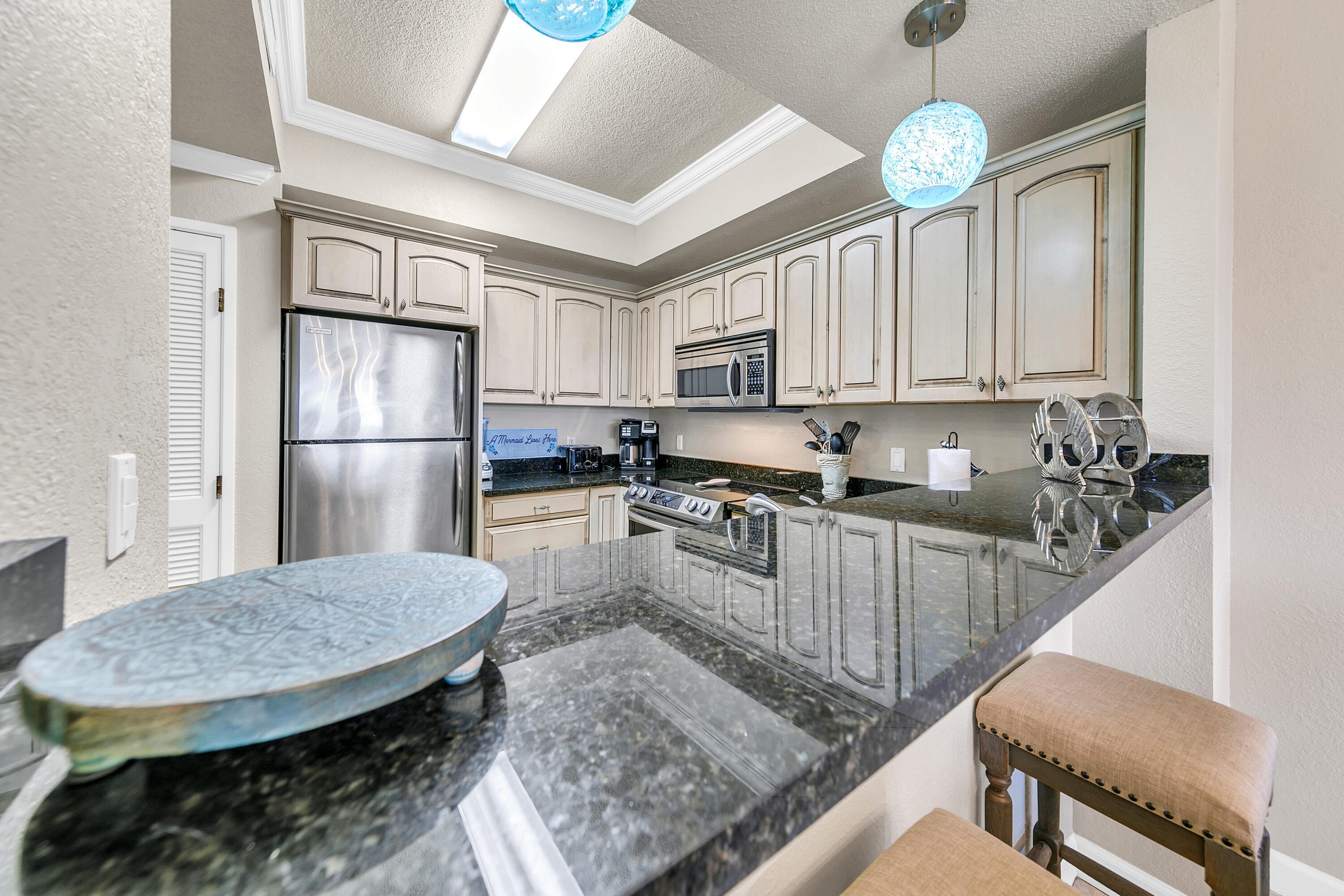 515 Tops'l Beach Boulevard, Unit 913 Miramar Beach, FL 32550 - Photo 10 of 34 a kitchen with stainless steel appliances granite countertop a sink window and cabinets
