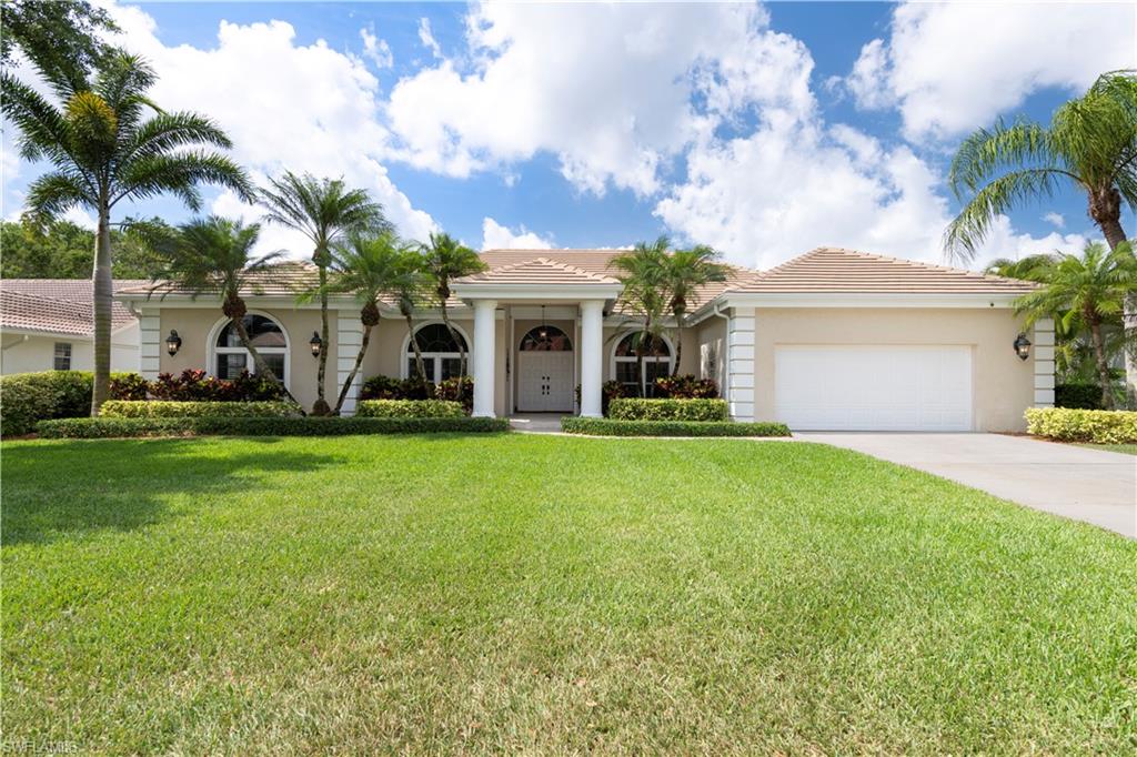 217 Silverado Drive Naples, FL 34119 - Photo 1 of 18 a front view of house with yard and green space