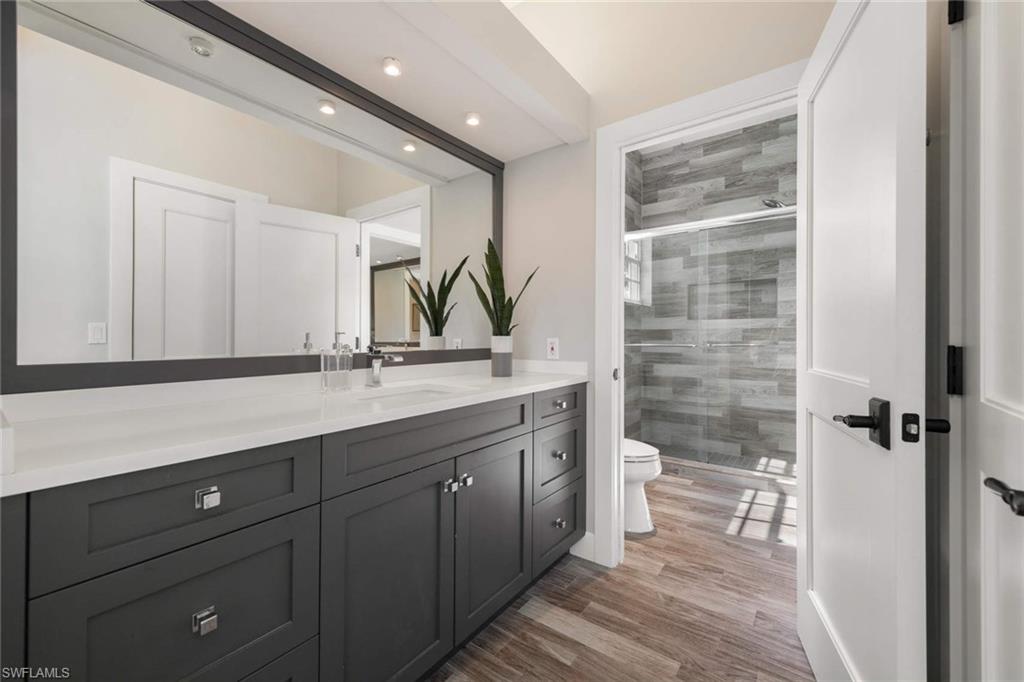 217 Silverado Drive Naples, FL 34119 - Photo 11 of 18 a bathroom with a double vanity sink and a toilet