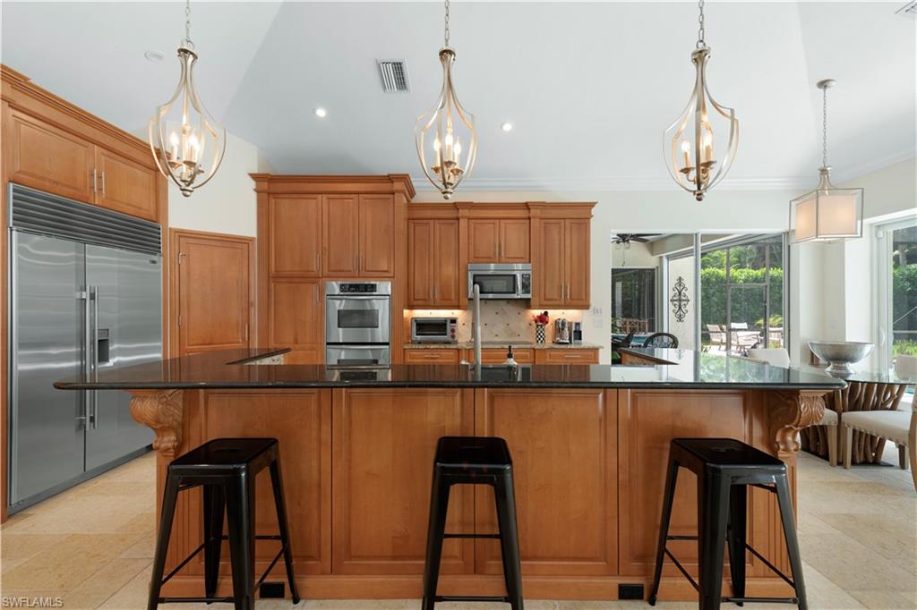 217 Silverado Drive Naples, FL 34119 - Photo 14 of 18 a kitchen with stainless steel appliances granite countertop counter space a sink and cabinets