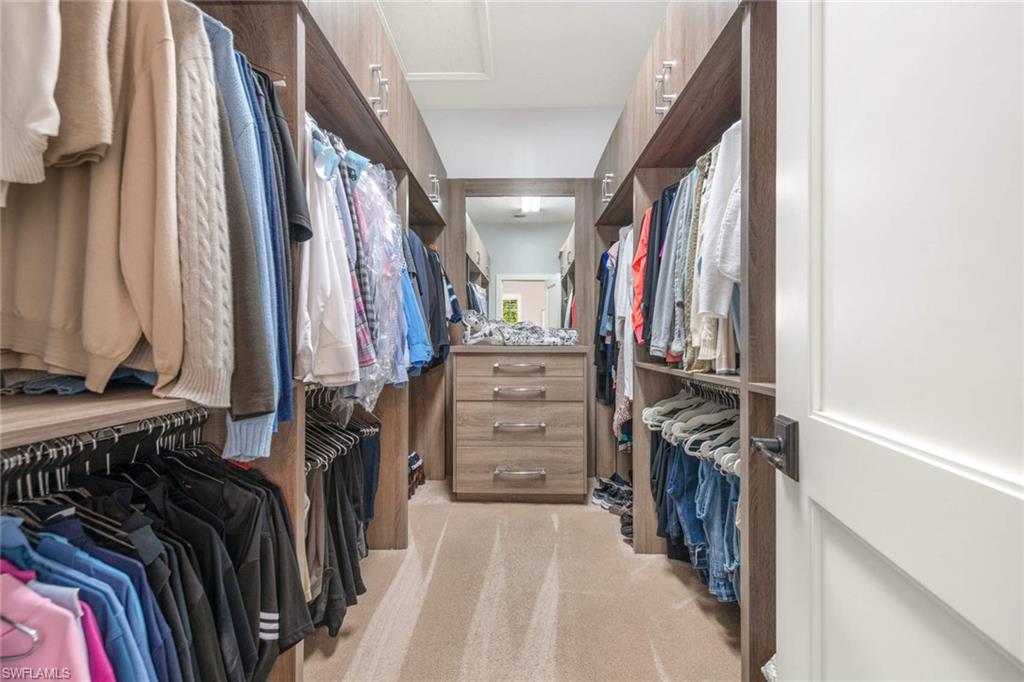 217 Silverado Drive Naples, FL 34119 - Photo 8 of 18 a view of walk in closet with clothes and shoes