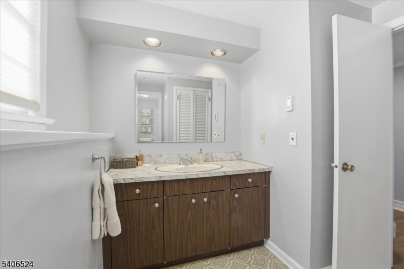 309 North Road Chester, NJ 07930 - Photo 23 of 37 a bathroom with a granite countertop sink a mirror and a vanity