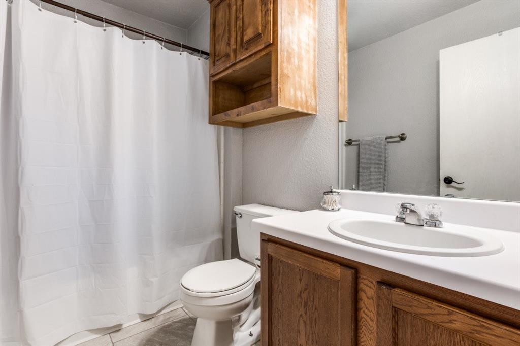 Undisclosed Address Austin, TX 78744 - Photo 9 of 18 a bathroom with a sink a toilet and shower curtain