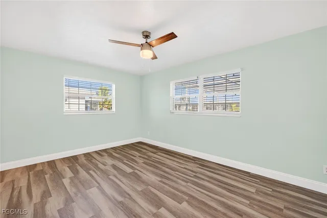 a view of a big room with wooden floor and windows