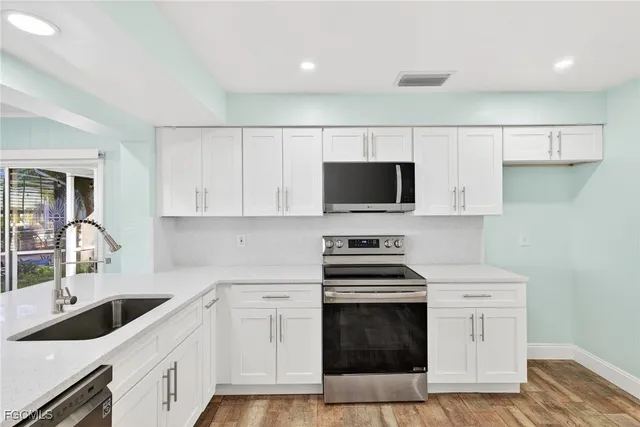 a kitchen with a sink stove and microwave