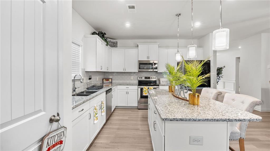 3 Joplin Street Northeast Rome, GA 30161 - Photo 3 of 26 a kitchen with kitchen island granite countertop a sink a counter space appliances and cabinets