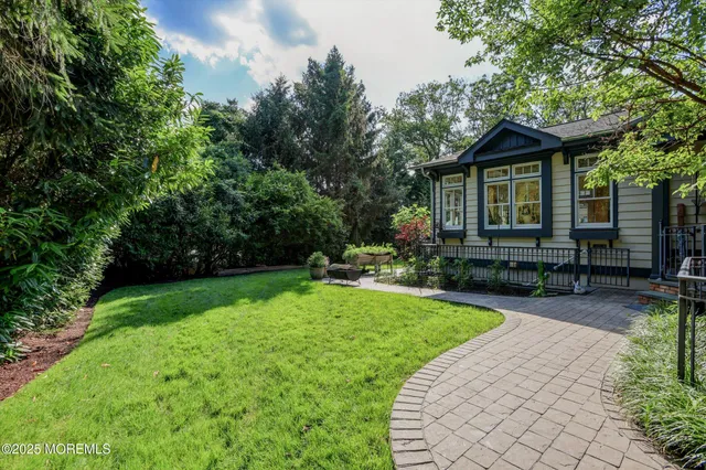 an aerial view of residential house with outdoor space and trees all around